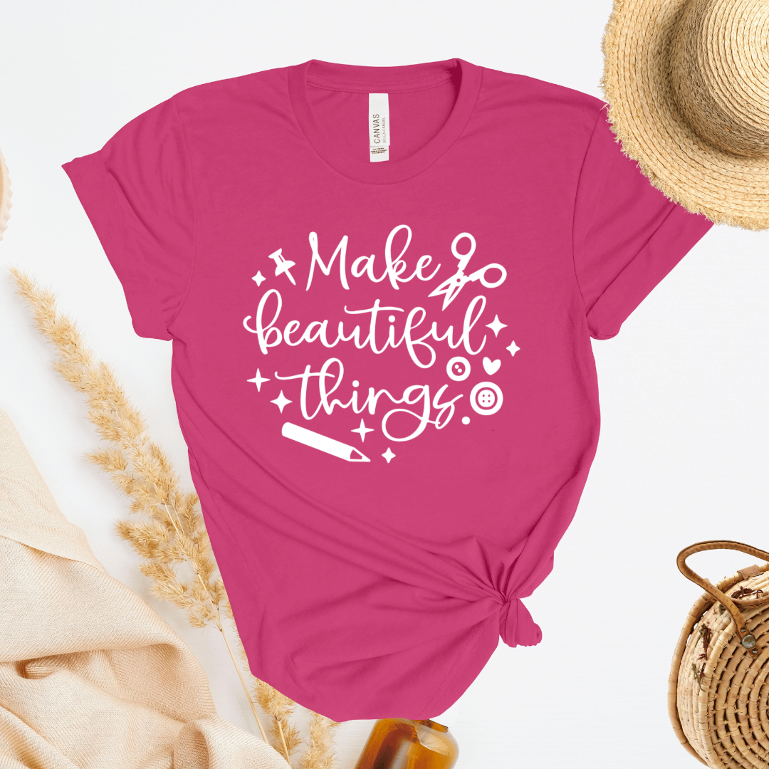 Pink t-shirt with 'Make beautiful things' text on a white background