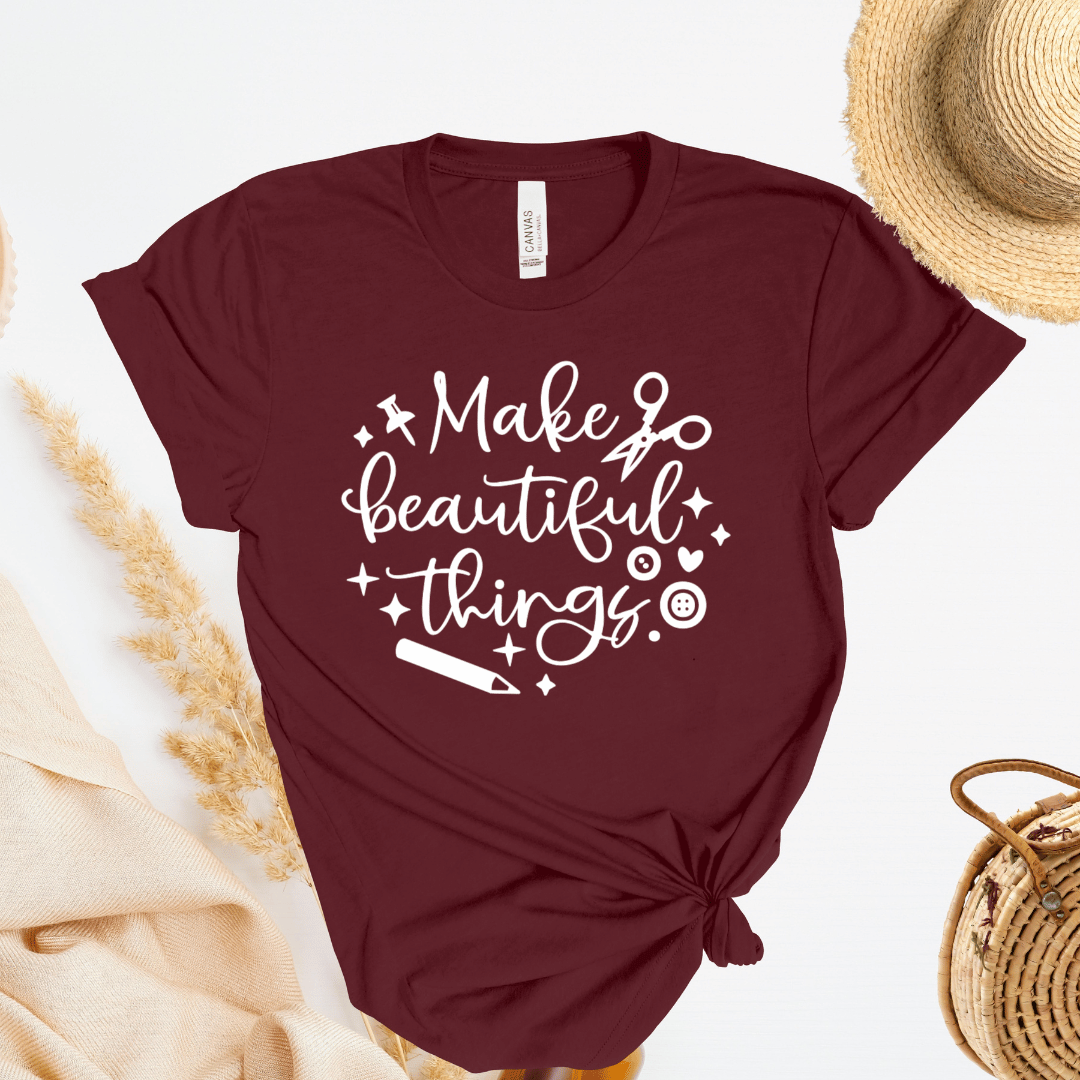 Maroon t-shirt with 'Make beautiful things' text on a light background