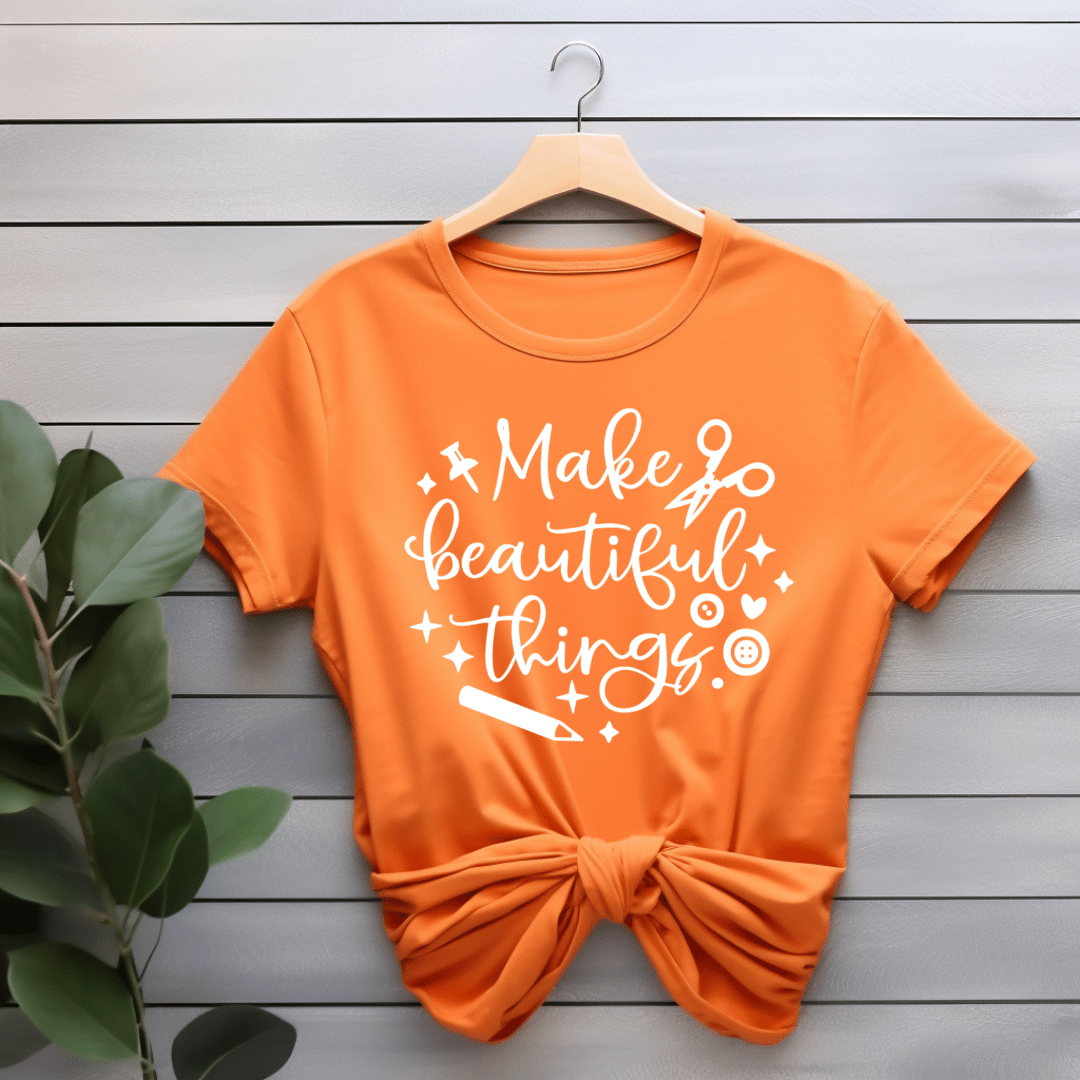 Orange t-shirt with 'Make beautiful things' text on a wooden background
