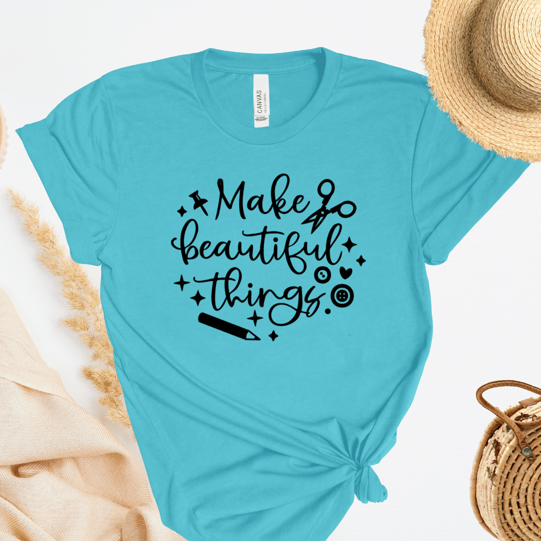 Turquoise t-shirt with 'Make beautiful things' text on a white background