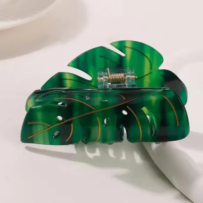 Green monstera leaf-shaped hair clip on a white background