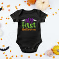 "My First Halloween" in purple, green, and orange lettering flanked by two white spiders on a black baby bodysuit