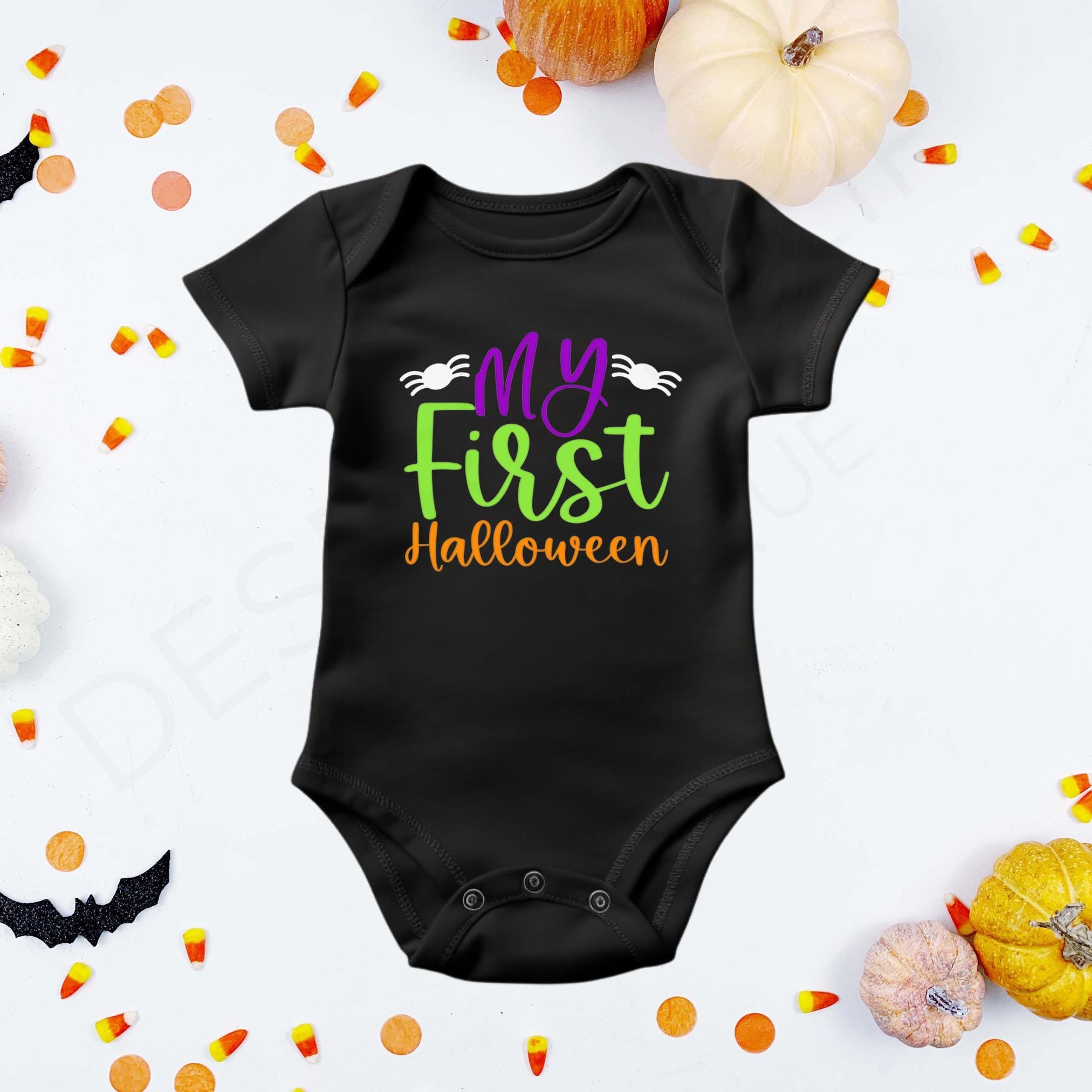 "My First Halloween" in purple, green, and orange lettering flanked by two white spiders on a black baby bodysuit
