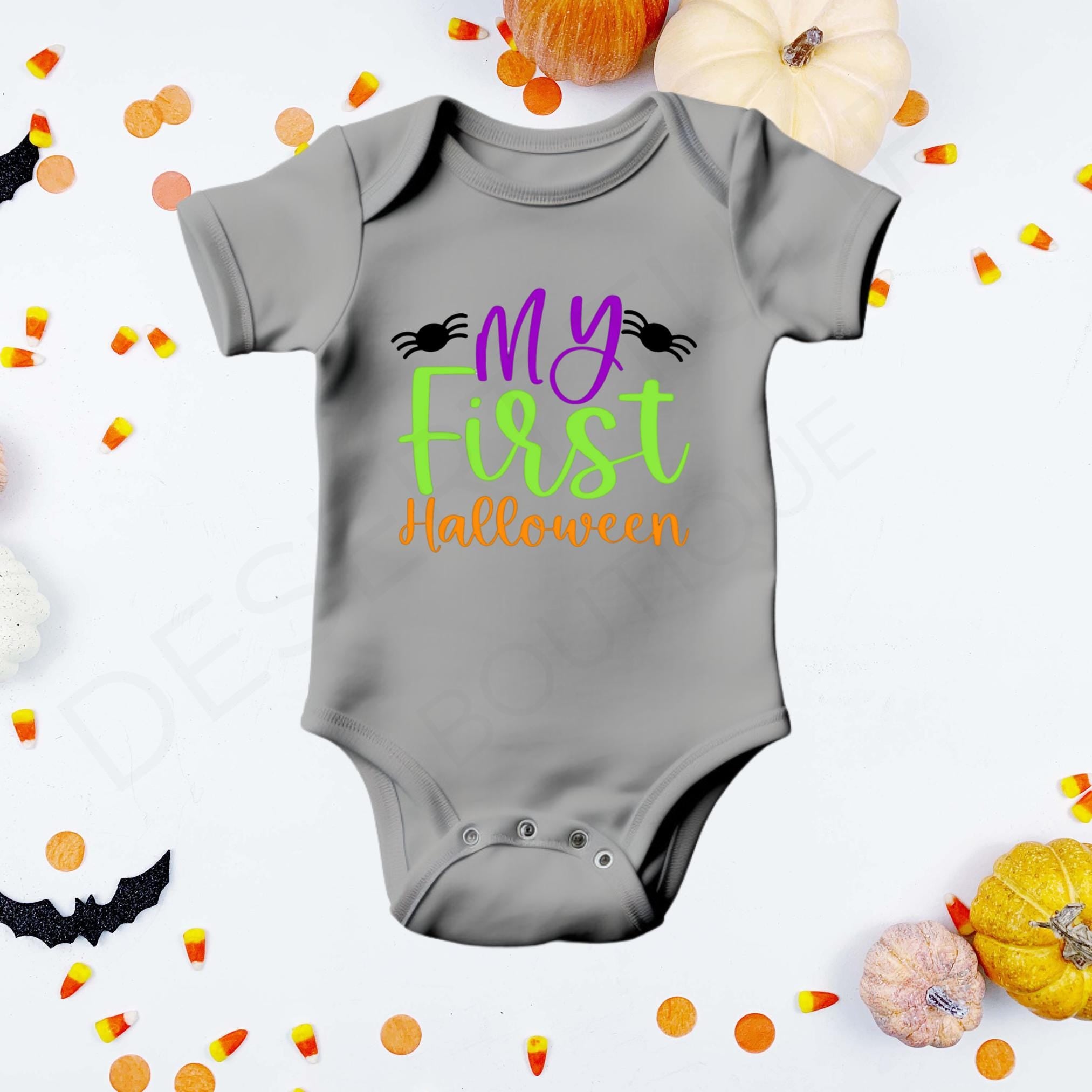 "My First Halloween" in purple, green, and orange lettering flanked by two black spiders on a gray baby bodysuit