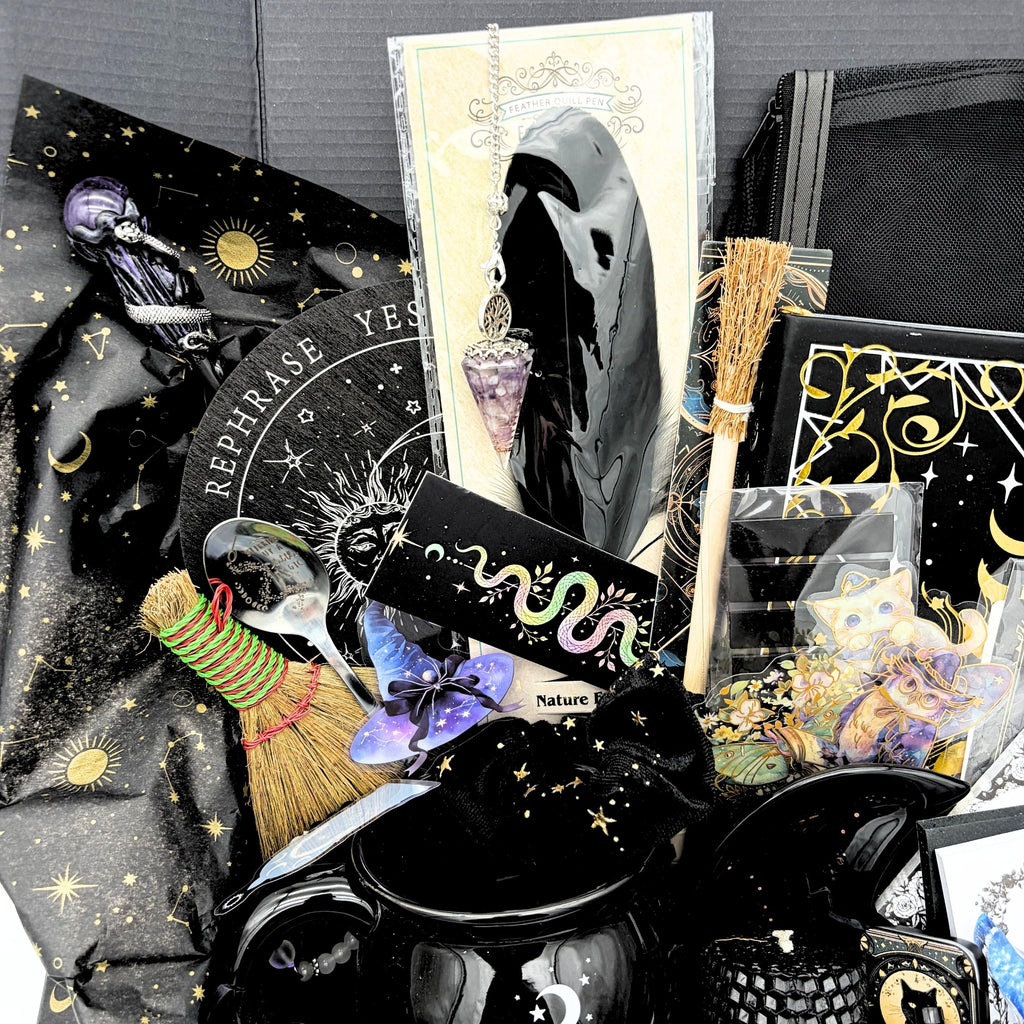 More than 30 pieces of the mystical witchy gift box arranged in black and gold celestial tissue around a witches brew cauldron mug