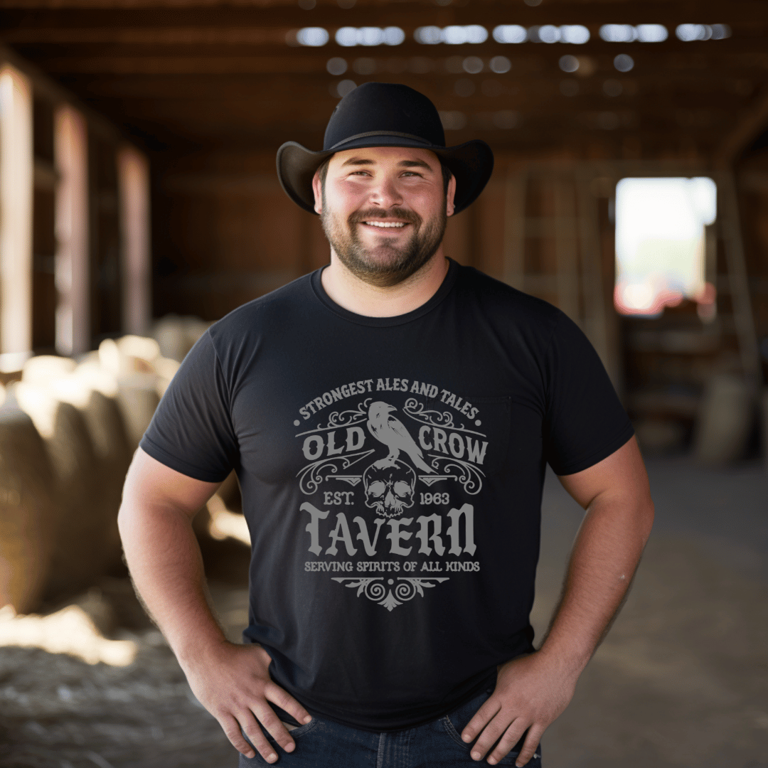 Man wearing a black t-shirt with 'Old Crow Tavern' design in a barn setting