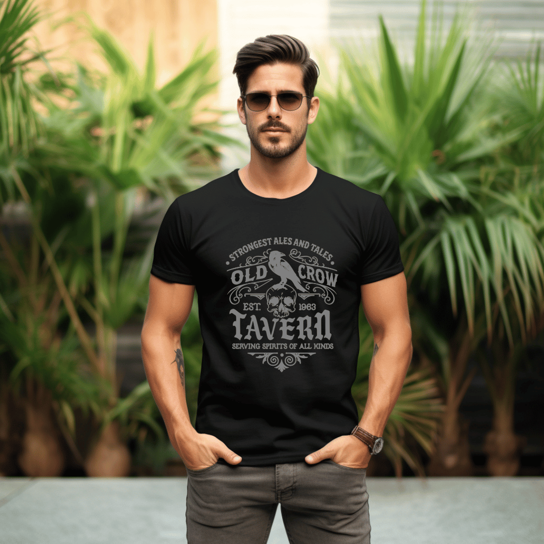 Man wearing a black t-shirt with an 'Old Crow Tavern' logo in front of green plants