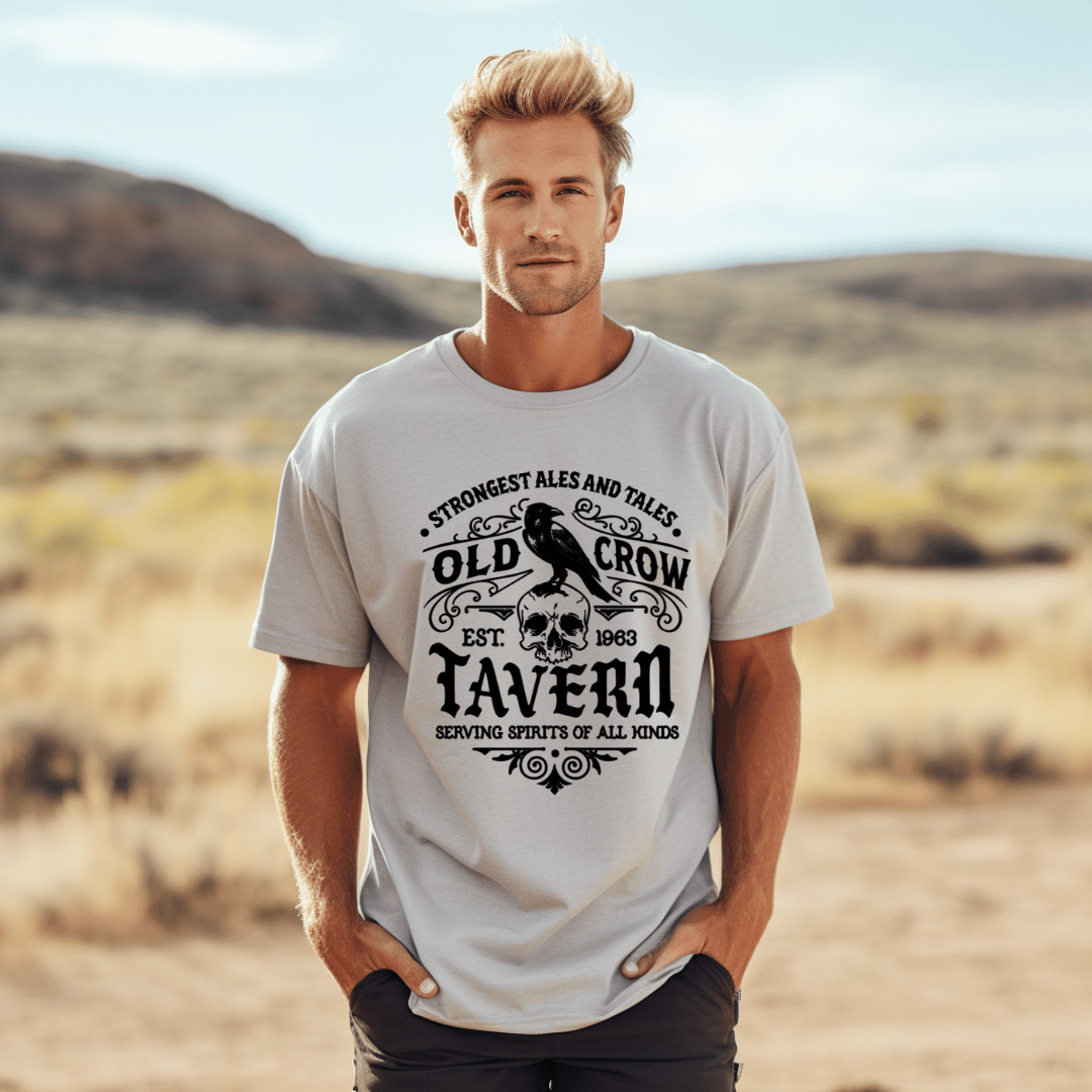 Man wearing a t-shirt with 'Old Crow Tavern' design in a desert setting