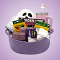 Purple ghost coloring book gift set in a purple rope basket with a sherpa ghost pillow, ghost straw tumbler, candle, and fuzzy socks