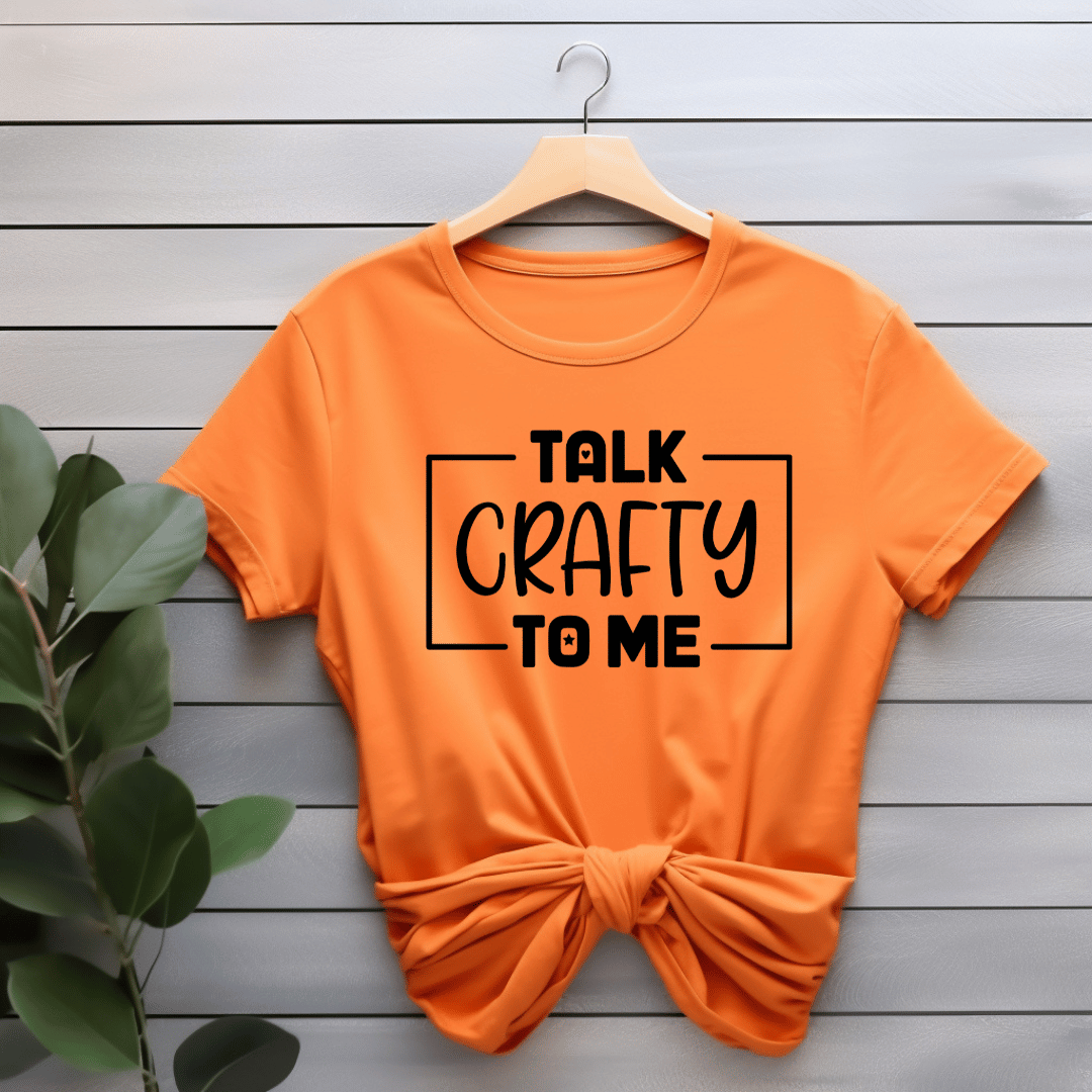 Orange t-shirt with 'Talk Crafty to Me' text on a wooden background