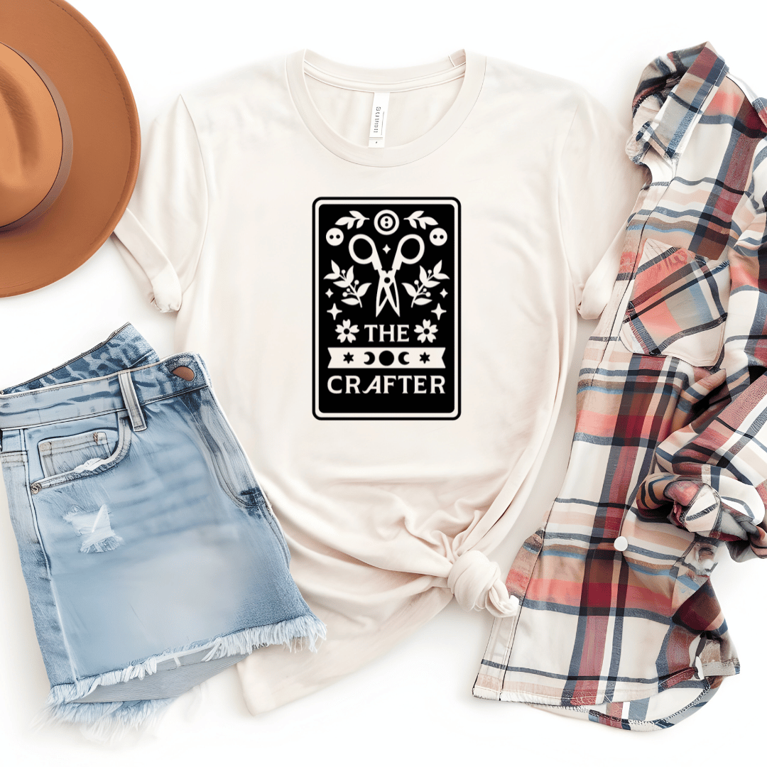 The Crafter tarot card t-shirt in natural tan with scissors, botanicals, and moon phase design