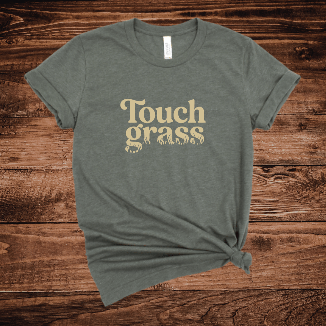 Touch Grass funny outdoor humor t-shirt with retro serif font and grass blade lettering on an army green shirt