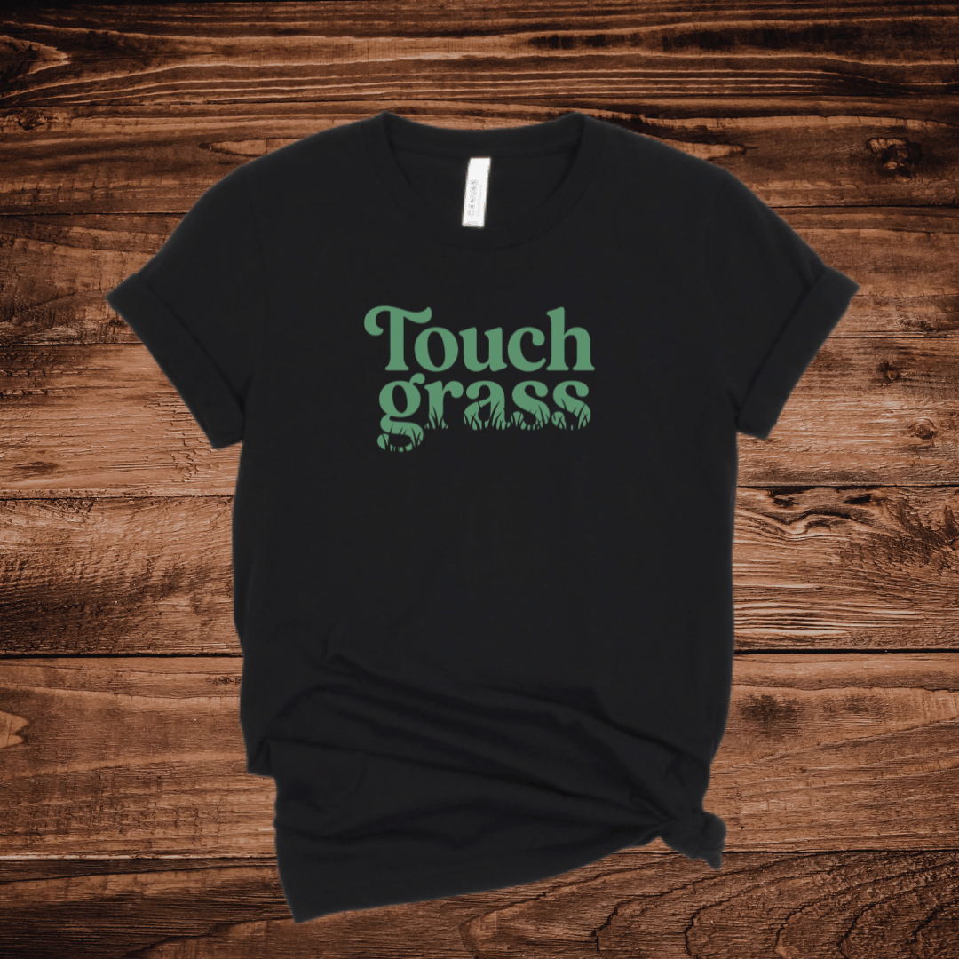 Touch Grass funny internet humor t-shirt with retro serif font and grass blade lettering on a black shirt