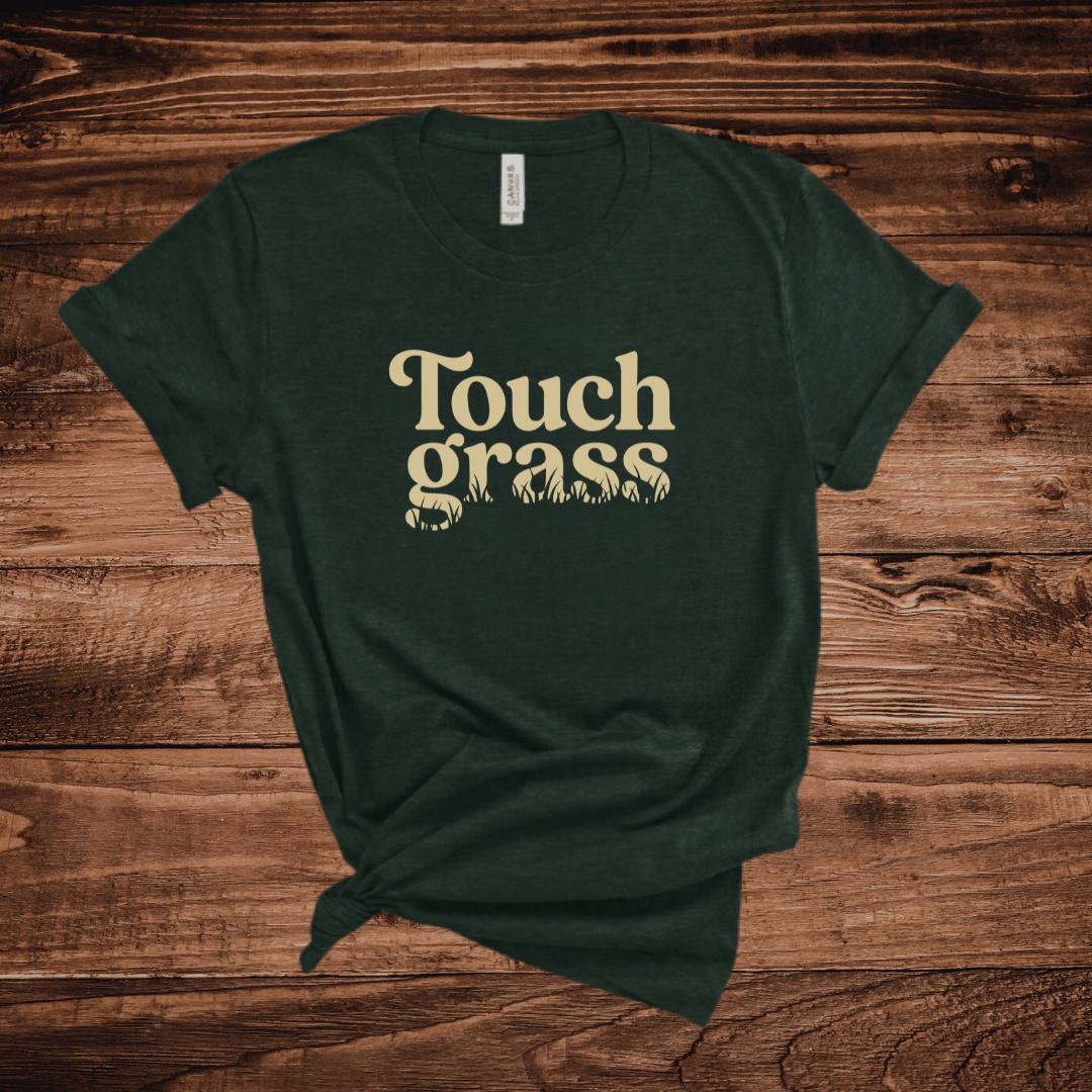 Touch Grass funny outdoor t-shirt with retro serif font and grass blade lettering on an emerald green shirt