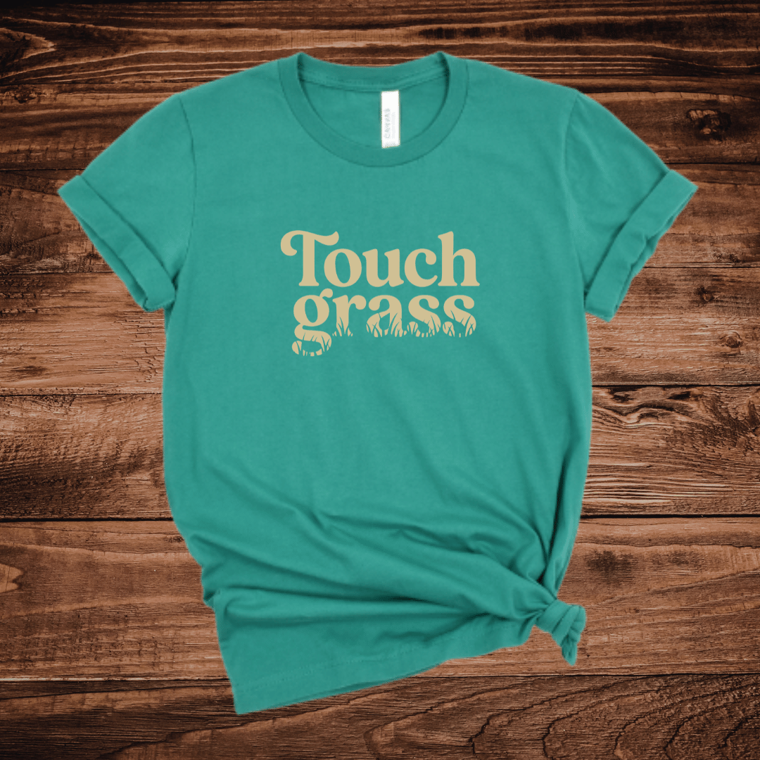Touch Grass funny nature lover t-shirt with retro serif font and grass blade lettering on a kelly green shirt