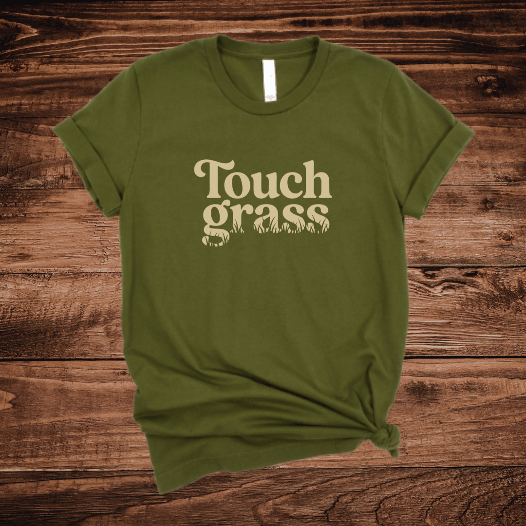 Touch Grass funny nature t-shirt with retro serif font and grass blade lettering on an olive green shirt
